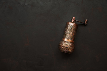 Turkish pepper mill or grinder on dark wooden background. Top view. Copy space
