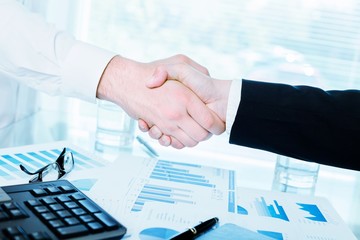 Business people counting on calculator sitting at the table.