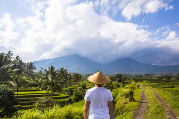 Fototapeta na wymiar Man with traditional balinese cap at rice fields of Jatiluwih in southeast Bali