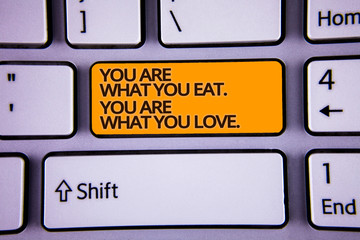 Handwriting text writing You Are What You Eat. You Are What You Love.. Concept meaning Start to eat healthy food Silver color polished modern computer keyboard with yellow arrow button