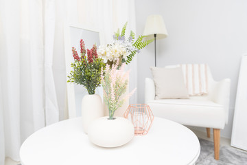 interior view of flower and vase on white table in living room.