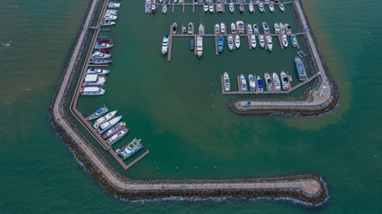 Fototapeta na wymiar Aerial view of yachts and boat berthed in the marina, Yacht parking, marina lot, Yacht and sailboat is moored at the quay.