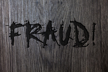 Word writing text Fraud Motivational Call. Business concept for Criminal deception to get financial or personal gain Wooden wood background black engraved letters words ideas messages concepts