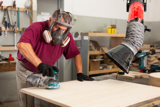 Worker Grinds The Wood Plank Of Angular Grinding Machine