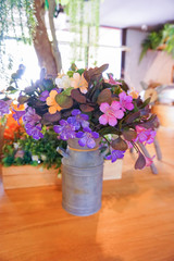vintage bouquet of flowers in metal pot, cafe background