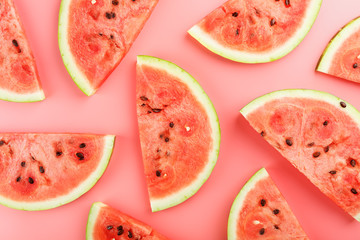 Slices of red watermelon on a pink background in the form. Minimal food concept idea. Flat lay, top view.