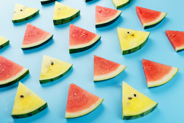 Slices of fresh slices of yellow and red watermelon on a blue background. View from above