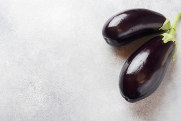 Fresh eggplant on grey concrete background with copy space.