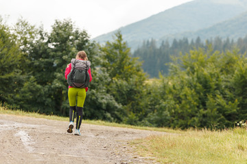 Obraz premium Young traveller with a backpack enjoying a hike through the forest. Travel concept.