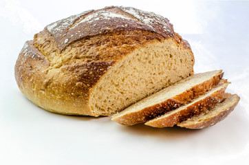 Dark rye bread with three slices on a white isolated background. 