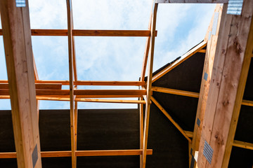 Roof trusses covered with a membrane on a detached house under construction, visible roof elements, battens, counter battens, rafters.