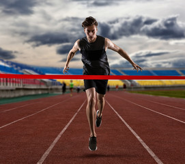 Fototapeta premium Sporty man running on the athletic track