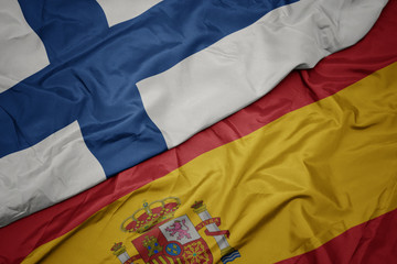 Fototapeta premium waving colorful flag of spain and national flag of finland.