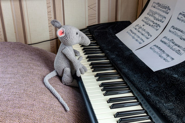 Amigurumi doll plays a musical instrument on sheet music.