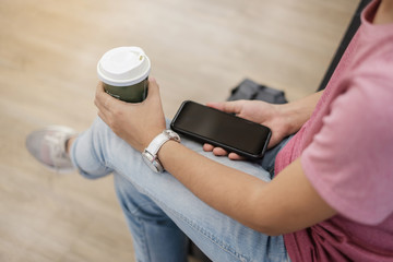 Young casual Businesswoman Sitting and using smartphone between drinking hot coffee. business, lifestyle, technology and Social media network concept