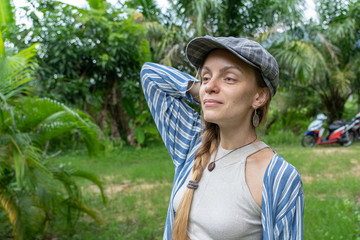 Closeup caucasian girl face in the cap. Portrait of young woman in nature