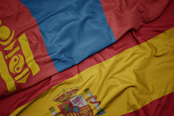 waving colorful flag of spain and national flag of mongolia.