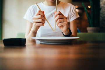 Pair of chopsticks in woman's hands