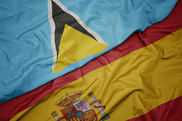 waving colorful flag of spain and national flag of saint lucia.