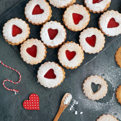 Top view of traditional Linzer cookies with red jam heart on dar