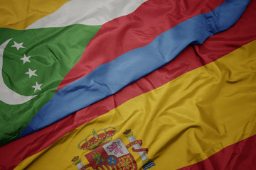 waving colorful flag of spain and national flag of comoros.