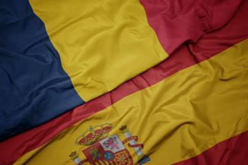 waving colorful flag of spain and national flag of chad.