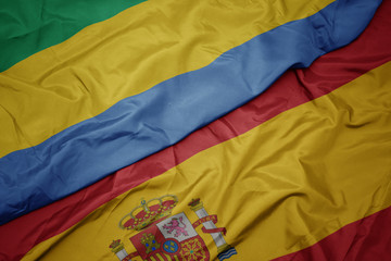 waving colorful flag of spain and national flag of gabon.