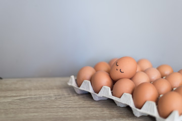 Egg with happy face in the basket with other eggs.