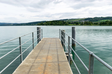 Fototapeta premium mall dock, calm and clear lake water, sky glare