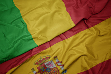 waving colorful flag of spain and national flag of mali.