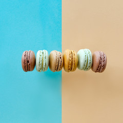 Row of weet and tasty macarons, flat lay on paper