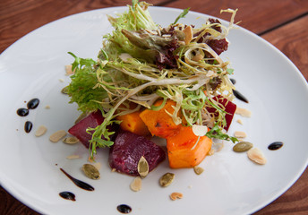 Autumn salad with pickled pumpkin and beetroot, fresh salad and pumpkin seeds. Close-up