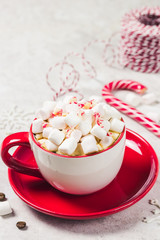 Chrismas marshmellow peppermint coffee in red cup on white marble background. Selective focus, space for text.
