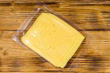 Sliced cheese and parsley in plastic container on wooden table. Top view