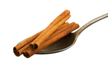 Dry hazel sticks in an old spoon isolated on a white background. Seasoning on isolate. View from above. Close up view of cinnamon.