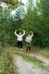 Fototapeta premium Portrait of old couple walking in autumn forest