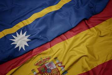 waving colorful flag of spain and national flag of Nauru.