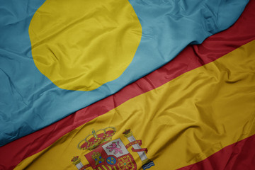 waving colorful flag of spain and national flag of Palau.