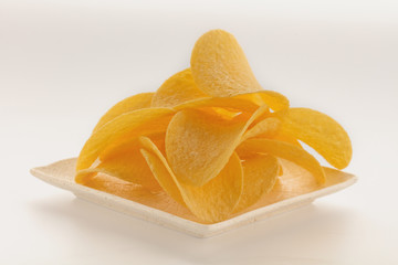 Potato chips on the plate  isolated white background. Side view.