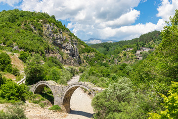 Fototapeta na wymiar The stone Plakidas bridge (Kalogeriko) with dried up river in Zagori region (Vikos Gore national park), Epirus, Greece