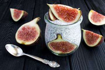 Pudding with chia and figs on the black wooden background. Closeup.