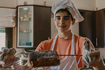 young chef with freshly made sweet or cake - obrazy, fototapety, plakaty