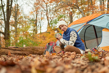 Couple of Canadian hikers setting up a tent in a fall forrest