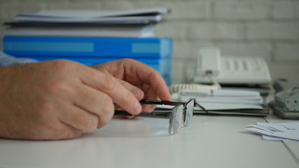 Businessman Image Playing with Glasses on the Table in Office Room