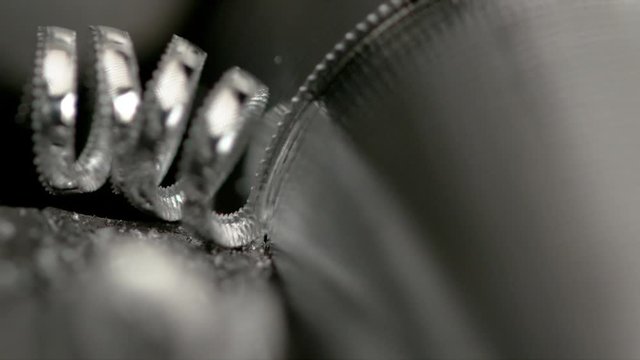 SLOW MOTION, MACRO, DOF: Sharp cutter cuts into steel cylinder as it is being processed into bolt. Detailed macro view of lathing equipment cutting into a small piece of aluminium. Automated metalwork