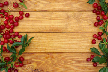 Fresh cherries with leaves on a wooden background