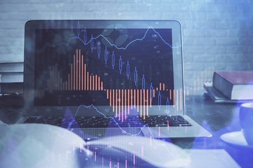 Stock market graph on background with desk and personal computer. Multi exposure. Concept of financial analysis.