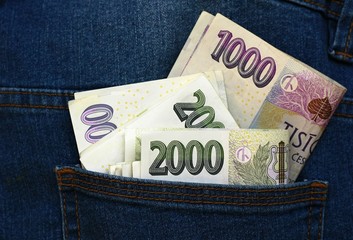 Several paper money in the back pocket of blue jeans.