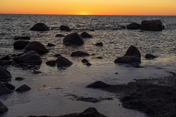 Baltic Sea. Silhouettes of stones at sunset. Beautiful sunrise on the sea. Views of Hiiumaa.