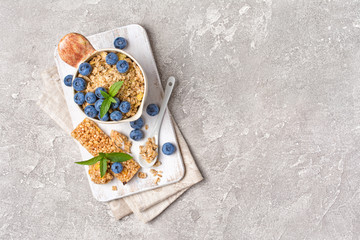 Fototapeta na wymiar Oat flakes with fresh blueberry and granola bar for healthy nutrition
